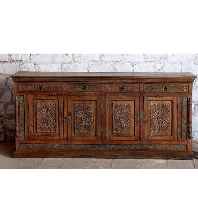 Elevate your living space with this antique hand-carved long sideboard, a striking blend of heritage craftsmanship and...