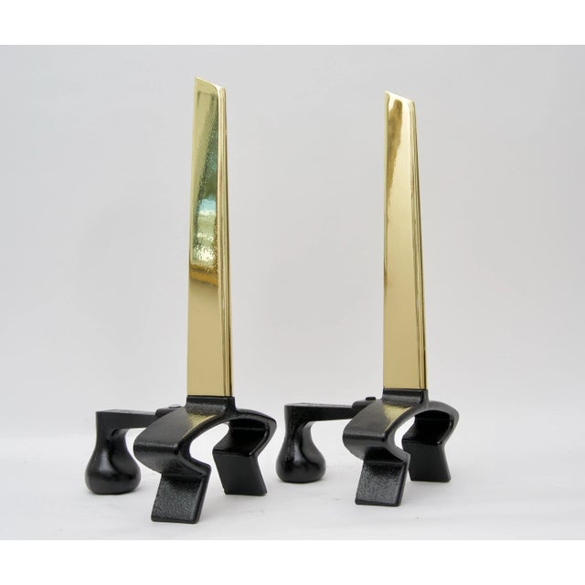 This stylish Mid-Century Modern set of andirons designed by Donald Deskey in polished brass and black iron date to the...