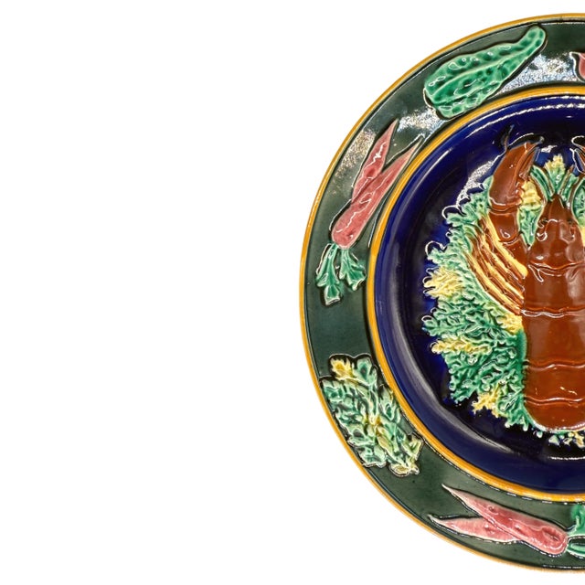 A Wedgwood Majolica Lobster Plate, with the central figure of a red-glazed lobster on sea greens on a cobalt blue ground,...
