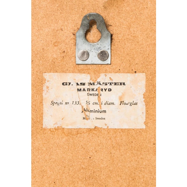 This circular model 133 mirror features an aluminum frame. This piece has an attribution mark, I am sure that it is...