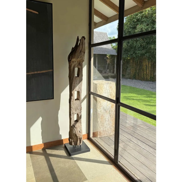 This striking artifact is an antique teak fence column from Java, Indonesia, once part of a traditional cow pen enclosure....