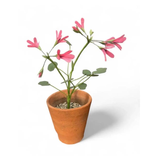 This handcrafted botanical sculpture features slender green metal stems with delicate pink paper flowers and rounded...