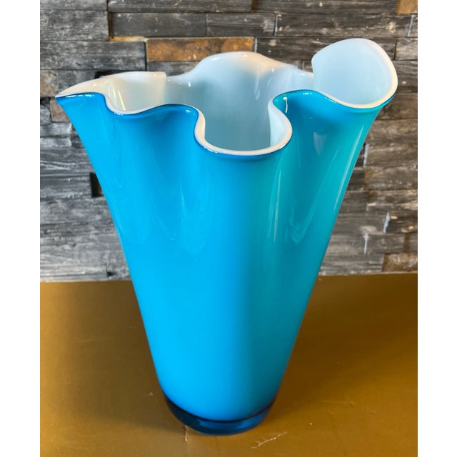 This vintage 16-inch tall hand-blown art glass vase has a handkerchief shape with a wavy lip. The captivating sky blue...