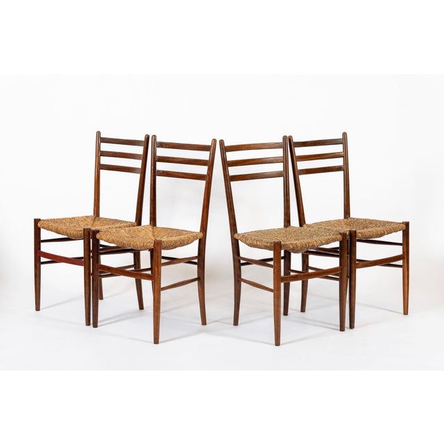 This set of four vintage rustic modern side chairs are circa 1960. The classic and elegant design features solid wood...