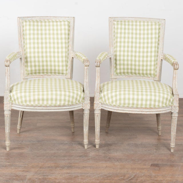 Pair of late 19th century Swedish Gustavian armchairs crafted in pine. The chairs feature fluted carved detailing...