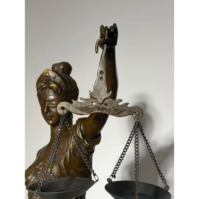 Impressive bronze sculpture depicting Lady Justice, blindfolded and holding scales and a sword. Her flowing robes and...