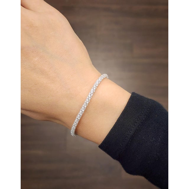 A luxurious tennis bracelet featuring 7.47 carats of 458 natural round-cut white diamonds, graded F/G color and VS2/SI1...