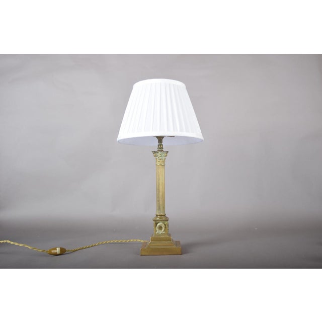 A refined gilded brass column table lamp with a beautifully balanced, architectural silhouette. The lamp features a fluted...