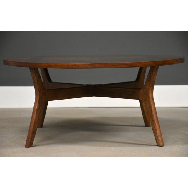 A mid century modern walnut round coffee table with canted legs. Professionally refinished. Circa 1960’s. Made in USA. 32”...