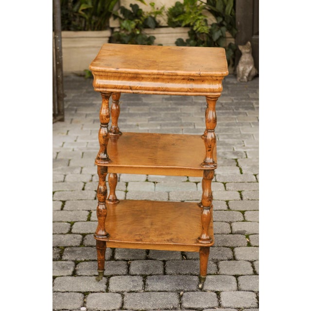 A French burl walnut tiered trolley from the late 19th century, with butterfly veneer, single drawer, turned legs and...
