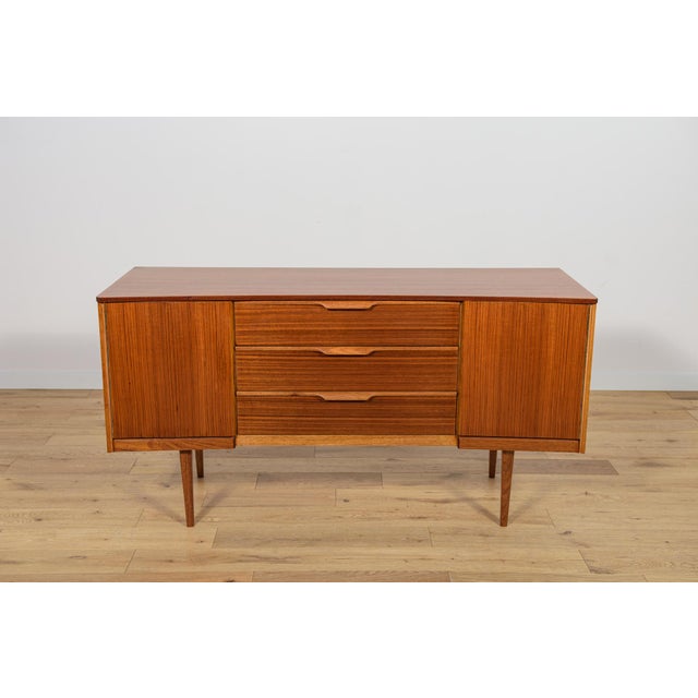 A small sideboard manufactured in the British Austinsuite factory in the 1960s. The chest of drawers consists of two...