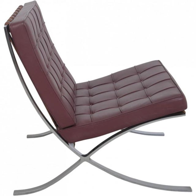Ludwig Mies van der Rohe Barcelona chair upholstered in burgundy colored leather, and with a steel frame. The chair is...