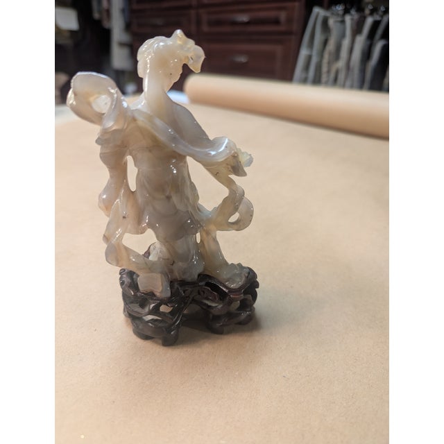 Vintage carved Jade Statue of a woman with a flowing dress and holding a paddle like fan. Sits on the original carved wood...