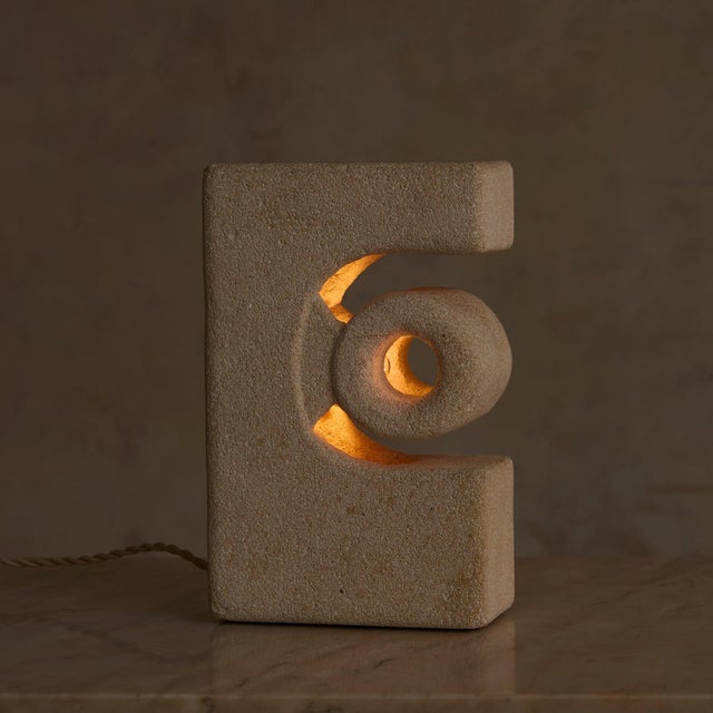 A French table lamp from the 1970s, attributed to Albert Tormos and hand-carved from solid limestone. The monolithic form...