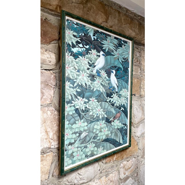 This painting on canvas depicts dense jungle foliage with tropical birds. The soft greens and flowering plants exude a...