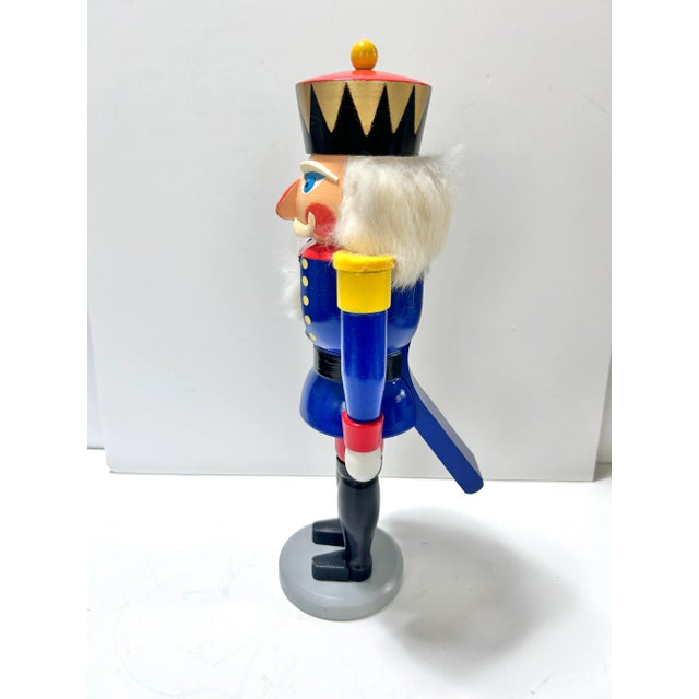 Vintage German wooden nutcracker from the Erzgebirge region, traditionally hand-painted in vivid blue, red, yellow and...