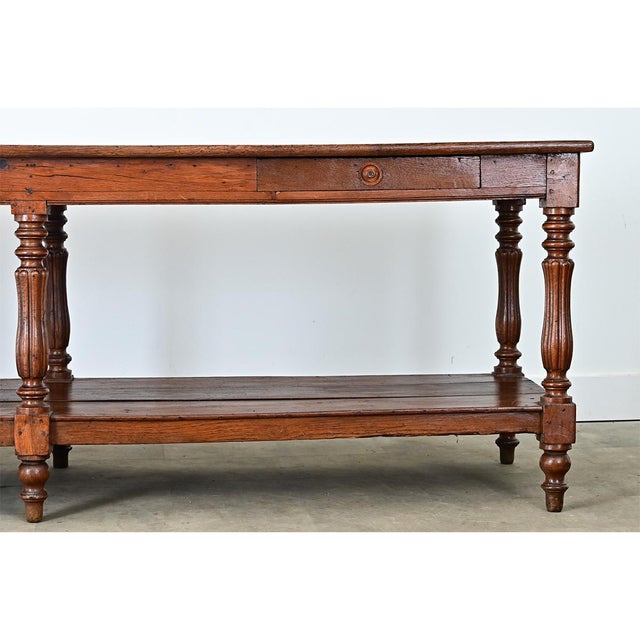 An expansive French oak drapery table from the 19th Century. The top is made from three planks of oak with stunning...