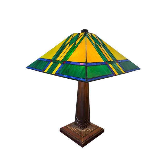 A beautifully crafted licensed Thomas Kinkade “Painter of Light” stained glass table lamp featuring a striking Prairie...