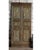 An exceptional pair of antique Indian carved wooden doors, featuring an elegant floral vase motif rendered in intricate...