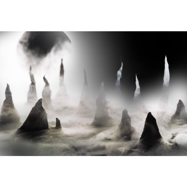 Eclipse on Q'sh presents a mesmerizing landscape where jagged peaks emerge from a shroud of mist, suggesting an...