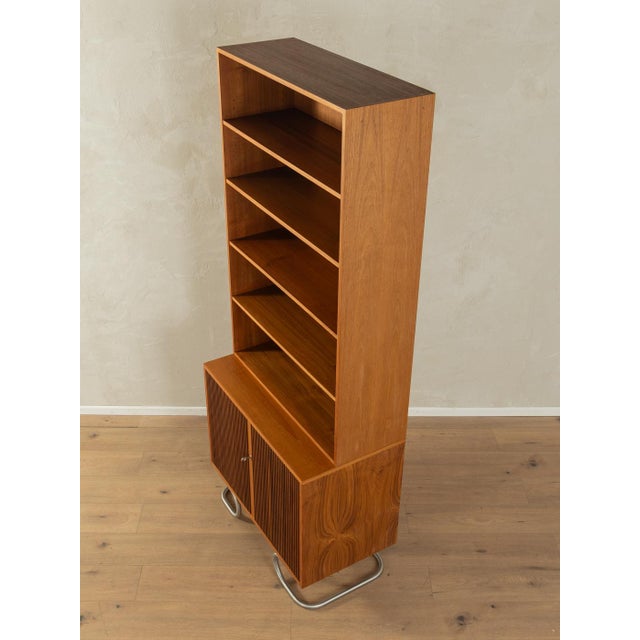 Classic two-piece chest of drawers from the 1960s. Body in teak veneer with two cabinet doors, five shelves and new steel...