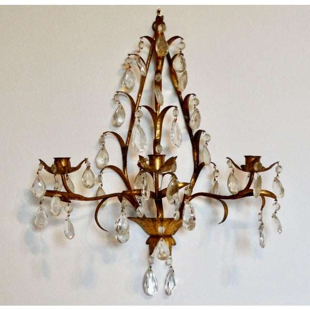 A lovely Mid 20th-Century Italian tole triple arm candle sconce with prism cut crystals. It has a decorative center...