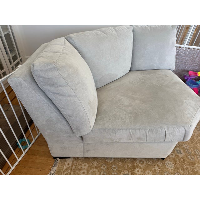 Light gray corner sectional piece is upholstered in a textured fabric with a subtle herringbone pattern. This wedge-shaped...