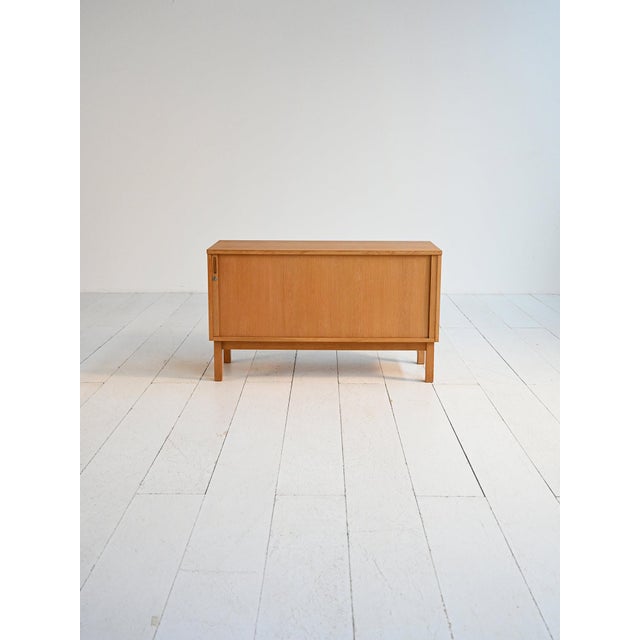 Oak filing cabinet with roller door, compartment with internal shelves, and a module with pull-out dividers for documents....