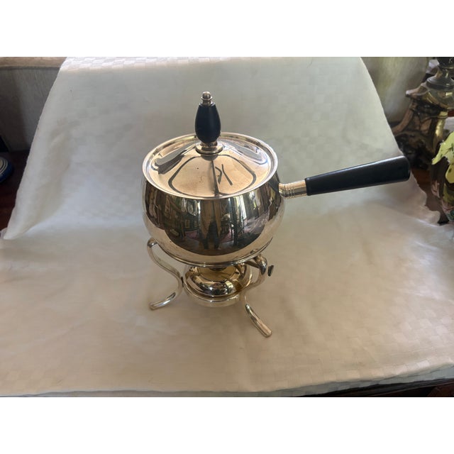 This classic mid century designed fondue pot includes a burner stand and the original burner. it has wooden handles and is...