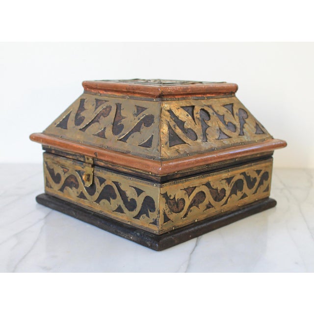 Vintage Indian dark wood trinket box with applied brass work in foliate design and copper sheet to the bullnose lid edges....