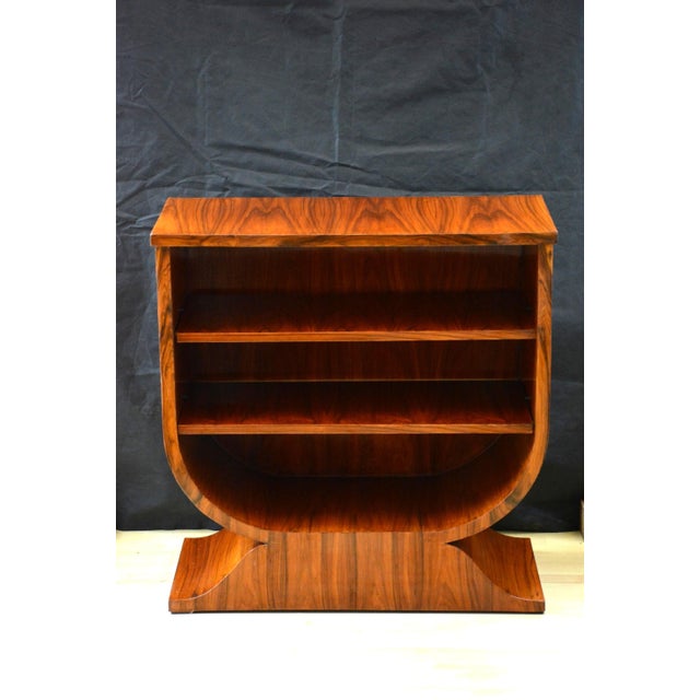 Outstanding pair of stylish and elegant tulip shaped art deco open bookcases in walnut, each having well figured...
