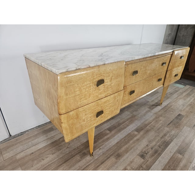 An elegant vintage chest of drawers from the 1950s, featuring a maple frame in warm honey tones, embellished with a...