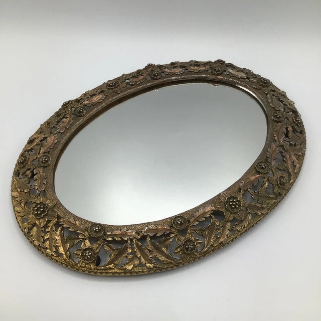 Oval brass flower and leaf gold gilt dresser or vanity mirror with scratch proof rubber feet. Great resting spot for your...