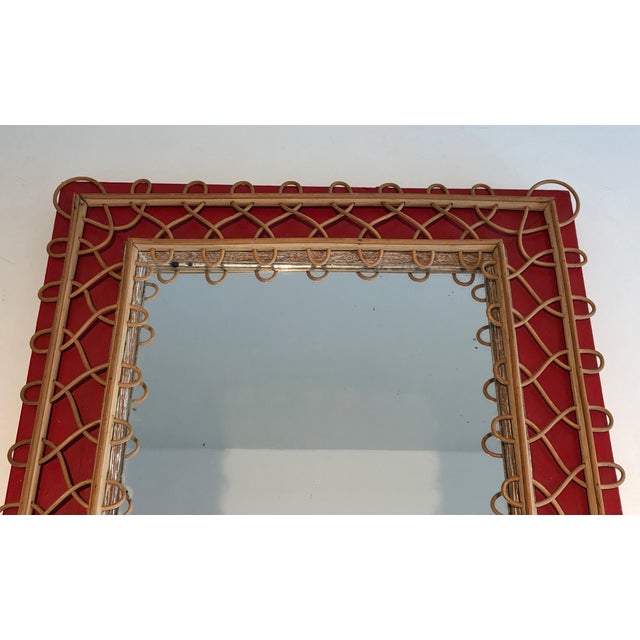 This very beautiful and unusual mirror is made of rattan on a red background. It is a French work. Circa 1940