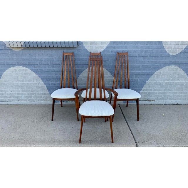 A set of four Mid-Century Modern Danish style high back walnut dining chairs - one armchair and three side chairs....