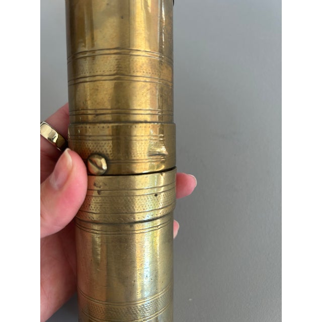 Features • Material: Solid brass with engraved detailing along the cylindrical body. • Design: Hand-crank handle that...