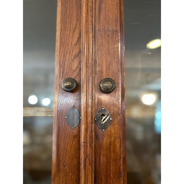 Superb and rare solid oak display cabinet dating from the 1920s, combining classic elegance with ample storage capacity....