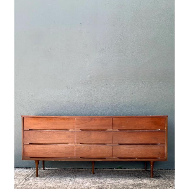 This exceptional vintage Mid-Century Modern Danish nine-drawer dresser is masterfully crafted from rich teak, beautifully...