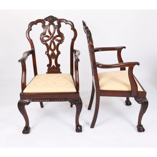 A beautiful antique set of twelve solid mahogany Chippendale Revival dining chairs, comprising ten sidechairs and two...