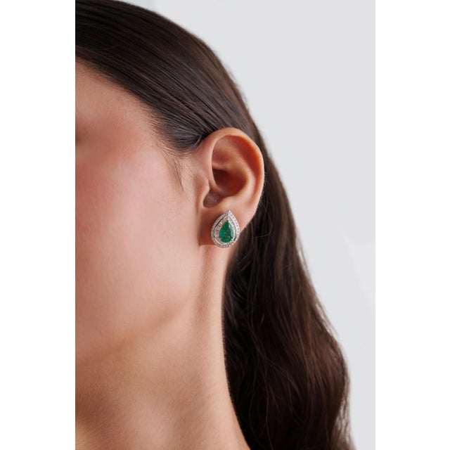 These Halo Stud Earrings feature 3.16 carats of vibrant pear-shaped emeralds, set in 18K White Gold. Each emerald...