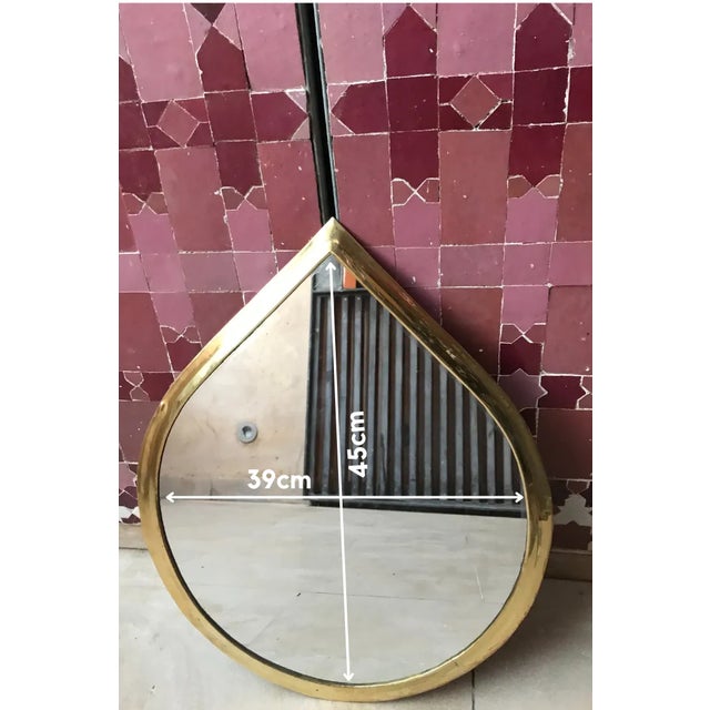 This Moroccan brass mirror is a truly unique and eye-catching piece. Shaped like a water drop, the mirror is both elegant...