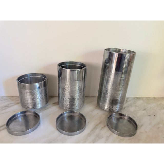 Set of three convertible candle holder/vases. Polished chrome throughout with striped etching below solid metal. All in...