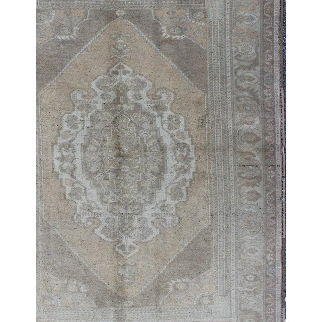 Muted vintage Turkish Oushak rug with large medallion design in light green, gray, light salmon and rust, Camel and taupe,...