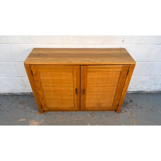 A stunning example of Mid-Century Modern design with a coastal influence. This versatile cabinet features a robust, solid...