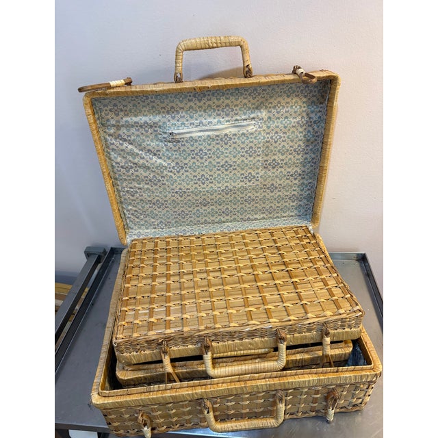 1950s-60s wicker nesting sewing/picnic baskets; set of 3. Lined in blue geometric floral print cotton. One basket lining...