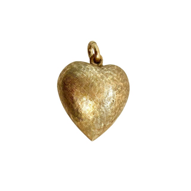A charming puffy heart pendant in solid 14 karat yellow gold from about the 1950s. Its rounded, dimensional form carries a...