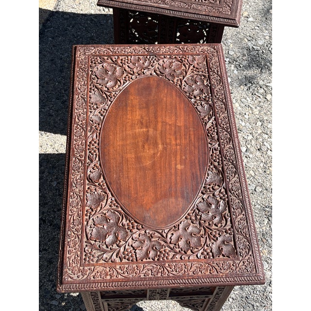 Pair of 19th century carved folding campaign tables. Probably teak wood. Top secured underneath with small peg. Label...