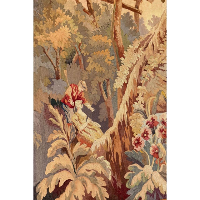 A richly decorative 19th-century French Continental wool tapestry in the Aubusson style, woven with an idyllic pastoral...