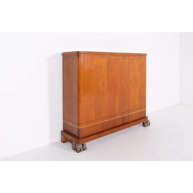 Art Deco cabinet by Erik Chambert, Sweden 1920s. Executed in veneer finish with spectacular lion sphinx front feet. The...