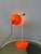 Orange space age eyeball desk lamp. The has an rvs frame that has an adjustable arm. The eyeball shade can be turned in...